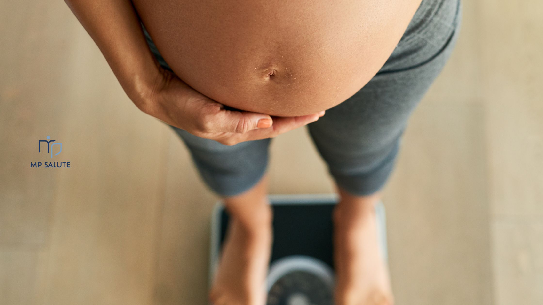 Donna in gravidanza che si misura il ventre o sale sulla bilancia