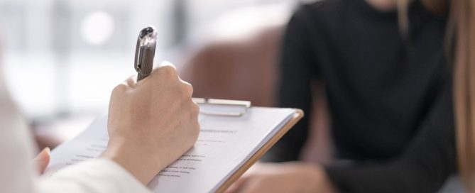 Professionista che prende appunti durante un colloquio psicologico